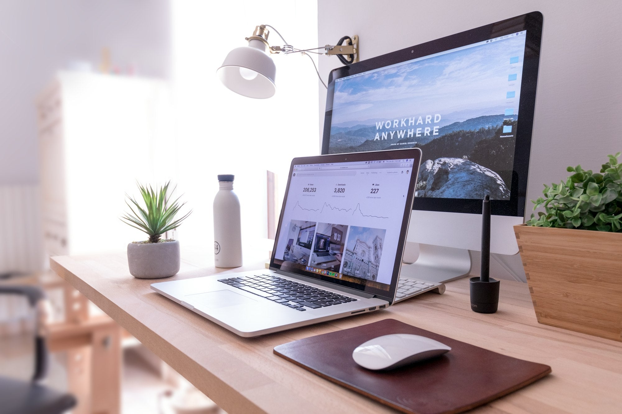 Squarespace vs Wix vs WordPress comparison, a web designer's workspace with laptop and desktop displaying a website