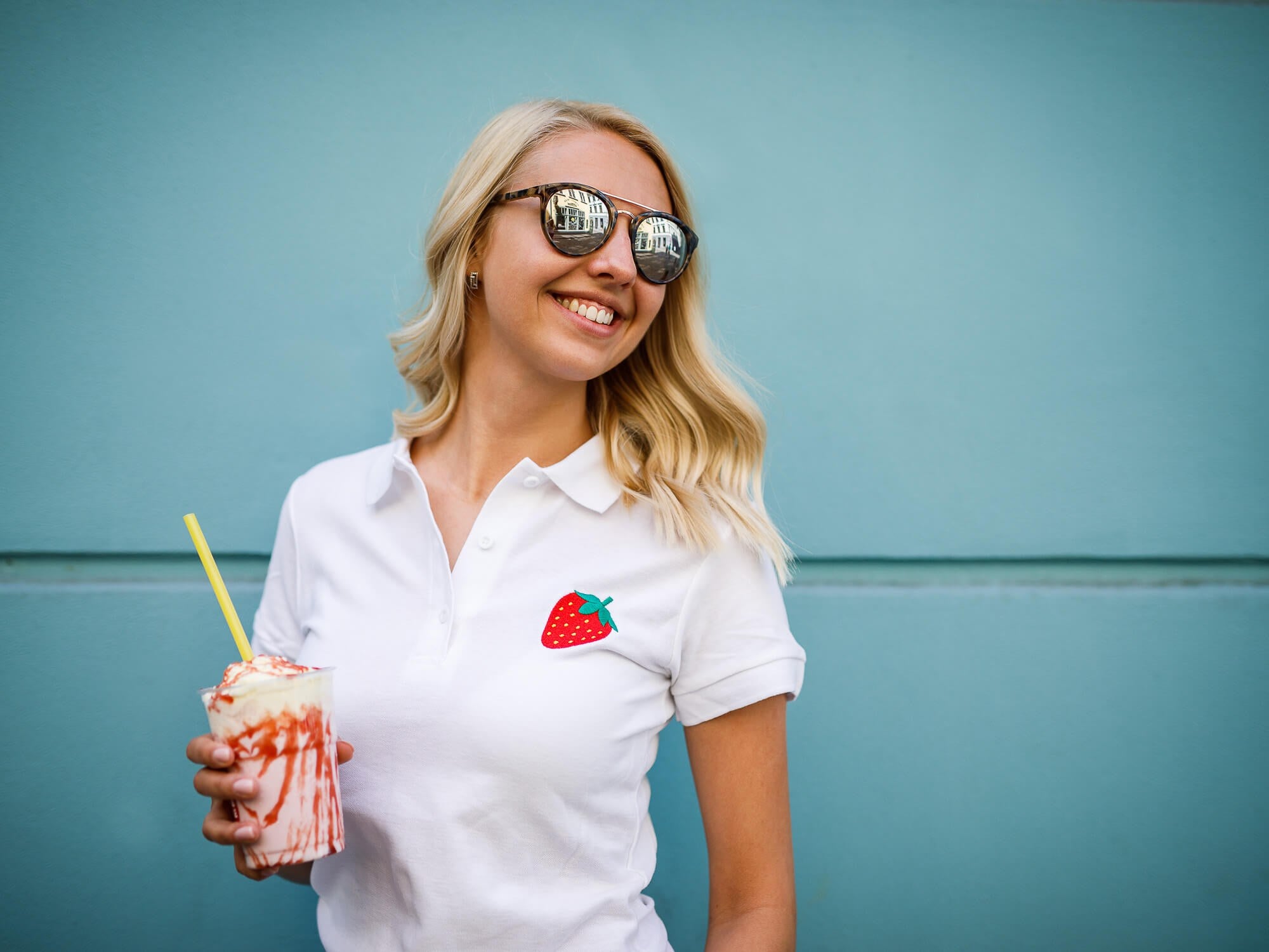 Model wearing a white printful polo with embroidered branding